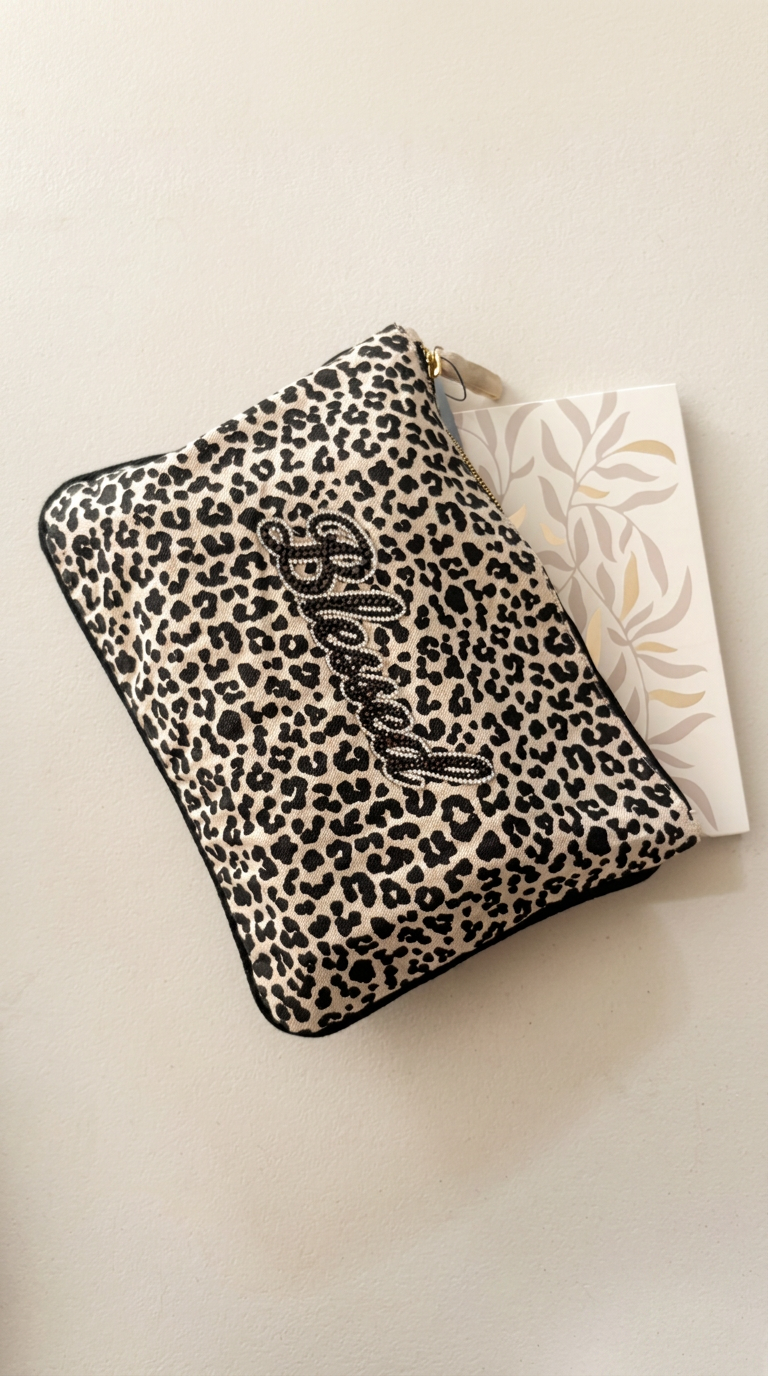 Blessed leopard pouch holding a botanical notebook