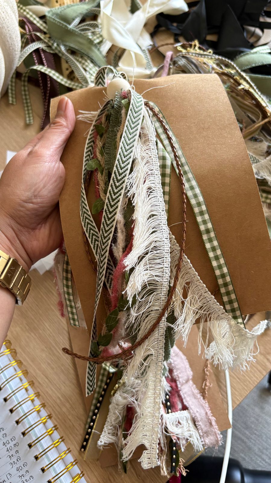 Sage green gingham and chevron ribbon Bible bookmark with cream fringe and eucalyptus trim held in hand