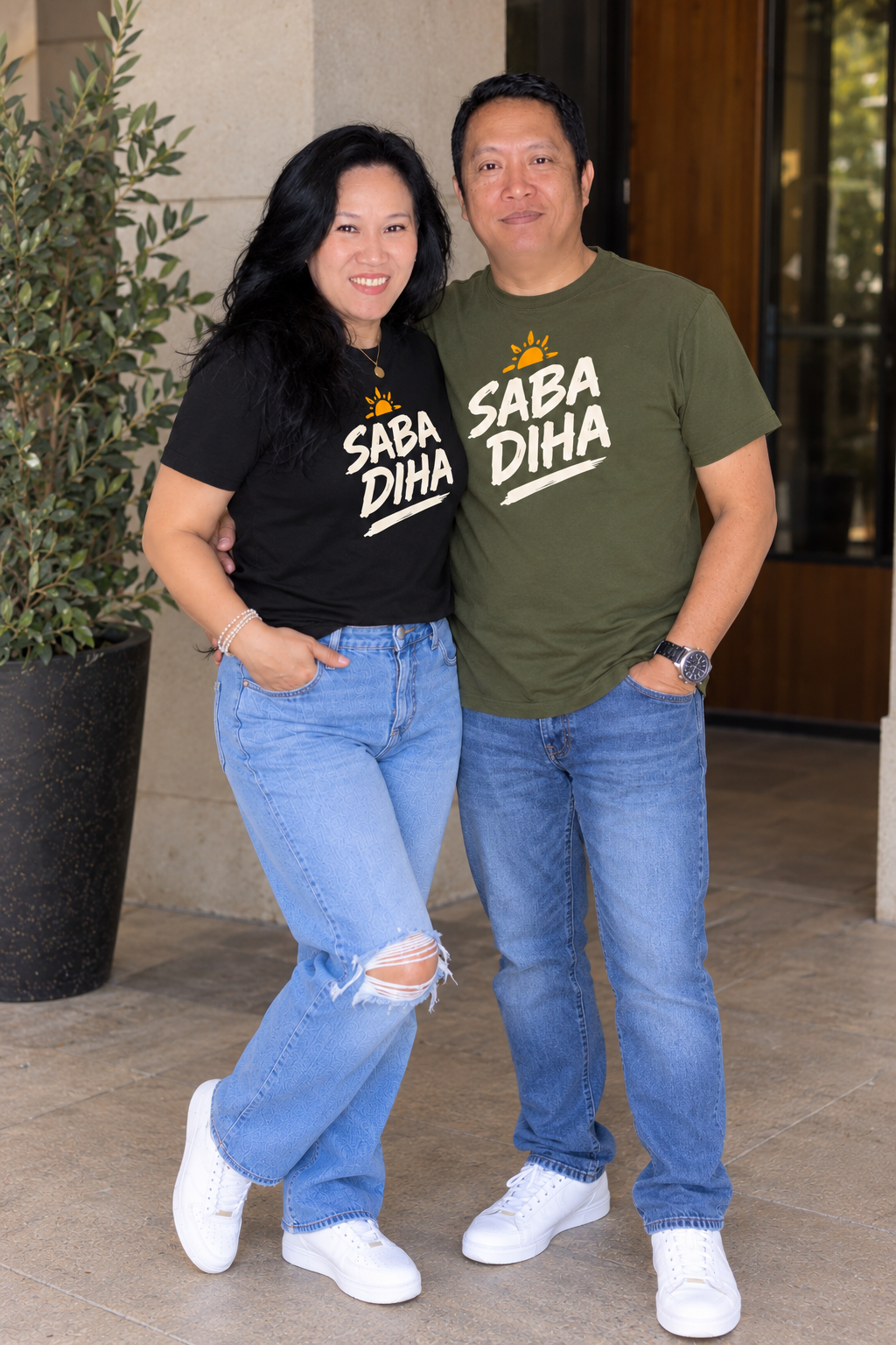 Couple wearing black and olive Saba Diha tees with jeans
